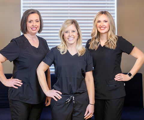 Three dental assistants from Neville Dental smiling