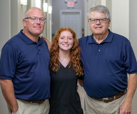 Two dentists from Neville Dental Studio smiling alongside one of their dental assistants